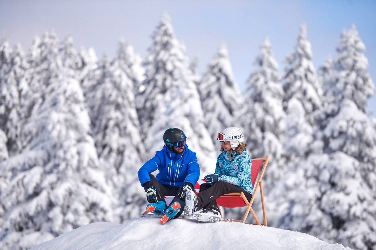 A couple on the snow in a ski outfit