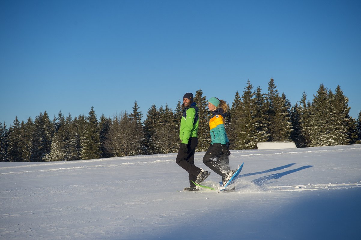 ein Paar auf Schneeschuhen in einer verschneiten Landschaft